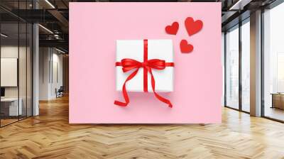 Beautiful gift box and red decorative hearts on pink background, flat lay Wall mural