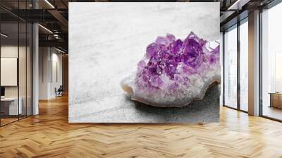 Beautiful purple amethyst gemstone on grey table, space for text Wall mural