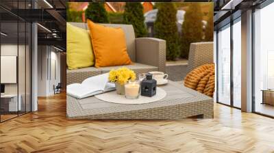 Beautiful rattan garden furniture, soft pillows and different decor elements outdoors Wall mural