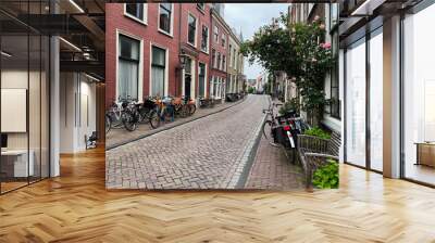 Beautiful view of city street with bicycles and pink rose bush Wall mural