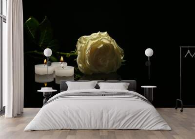 Beautiful white rose and candles on black background. Funeral symbol Wall mural