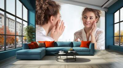 Beautiful woman applying moisturizing cream near mirror in bathroom Wall mural