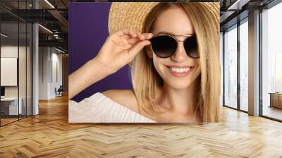 Beautiful woman in stylish sunglasses on purple background, closeup Wall mural