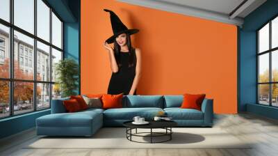 Beautiful woman wearing witch costume for Halloween party on yellow background, space for text Wall mural