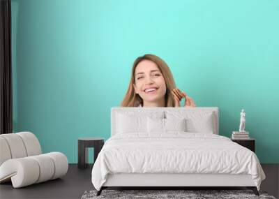 Beautiful young woman drinking milk with cookies on color background Wall mural