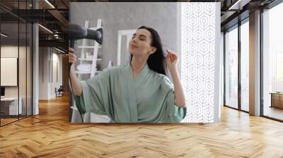 Beautiful young woman using hair dryer in bathroom Wall mural