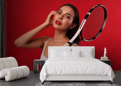 Beautiful young woman with tennis racket on red background Wall mural