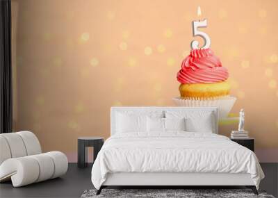 Birthday cupcake with number five candle on stand against festive lights, space for text Wall mural