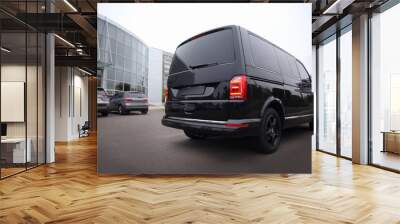 Black delivery van parked on street near building Wall mural