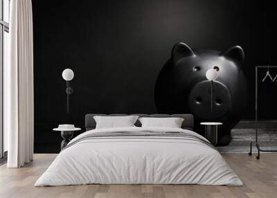 Black piggy bank on table against dark background with space for text. Poverty concept Wall mural