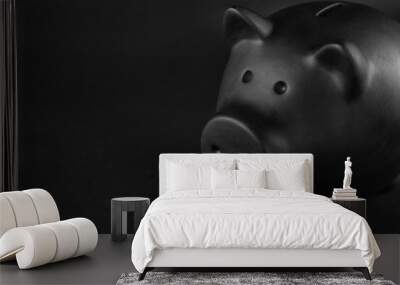 Black piggy bank on table against dark background Wall mural