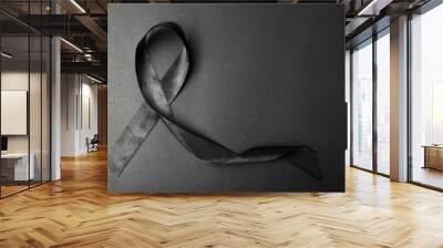 Black ribbon and space for text on dark background, top view. Funeral accessory Wall mural