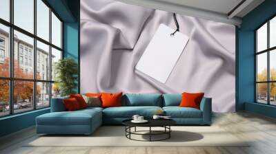 Blank tag on silver silky fabric, top view. Space for text Wall mural