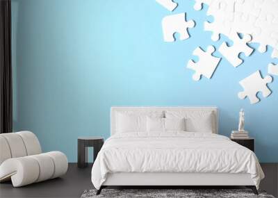 Blank white puzzle pieces on light blue background, flat lay. Space for text Wall mural