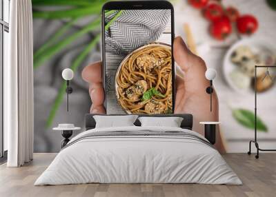 Blogger taking picture of delicious buckwheat noodles with meat at table, closeup. Food photography Wall mural