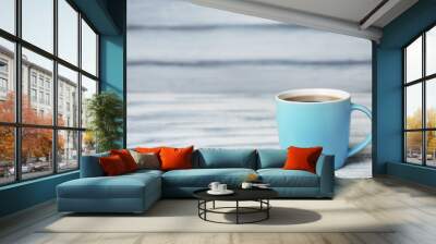 Blue ceramic cup with hot aromatic coffee on table Wall mural