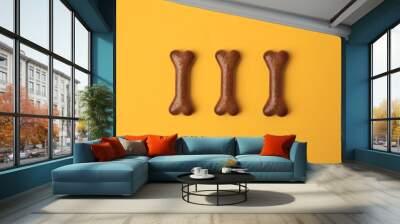 Bone shaped dog cookies on orange background, flat lay Wall mural