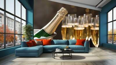 Bottle of champagne in bucket with ice and glasses on blurred background, closeup. Space for text Wall mural