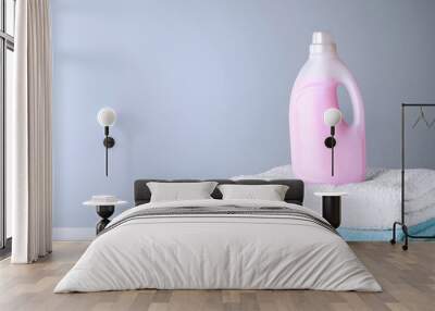 Bottle of laundry detergent and towels on table, space for text Wall mural