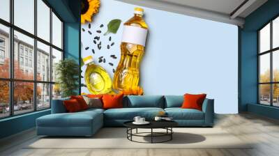 Bottles of sunflower cooking oil, seeds and beautiful flowers on light background, flat lay. Space for text Wall mural