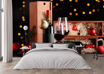 Bottles of wine, glasses, wooden boxes, fir twigs and Christmas balls on table Wall mural