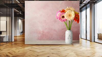 Bouquet of beautiful bright gerbera flowers in vase on marble table against color background. Space for text Wall mural