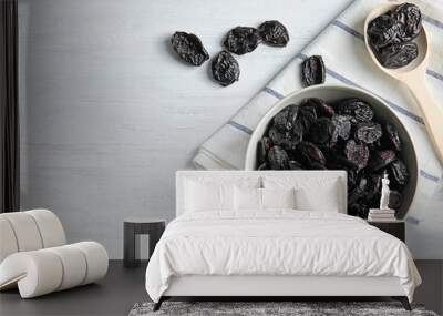 Bowl and spoon of sweet dried plums on table, top view with space for text. Healthy fruit Wall mural