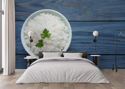 Bowl of cooked rice with parsley on wooden background, top view. Space for text Wall mural