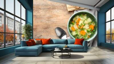 Bowl of fresh homemade vegetable soup served on wooden table, flat lay. Space for text Wall mural