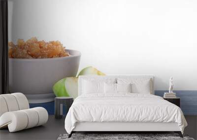 Bowl with delicious jam and pieces of apple on blue wooden table against white background Wall mural