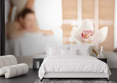 Bowl with sea salt and orchid flower on white table in spa salon. Space for text Wall mural