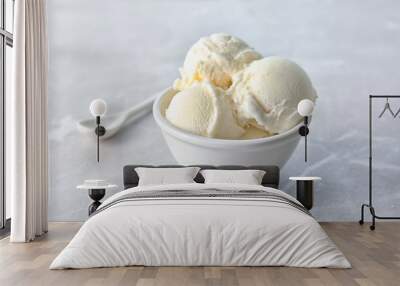 Bowl with tasty vanilla ice cream on light background Wall mural