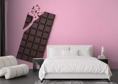 Broken dark chocolate bar on pink background, flat lay. Space for text Wall mural