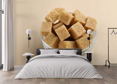 Brown sugar cubes in bowl on beige background, closeup Wall mural