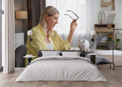 Budget planning. Woman using laptop at table indoors Wall mural