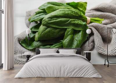 Bunch of fresh spinach leaves on white table, closeup Wall mural