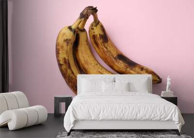 Bunch of ripe bananas with dark spots on pink background, top view Wall mural