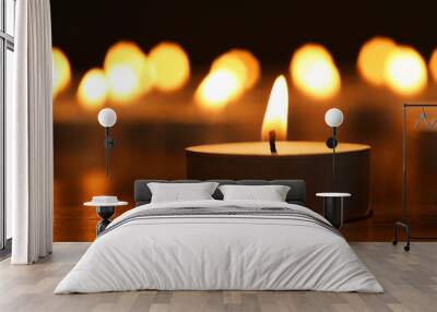 Burning tealight candle on dark surface, closeup Wall mural