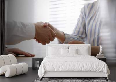 Business people shaking hands in office, closeup Wall mural