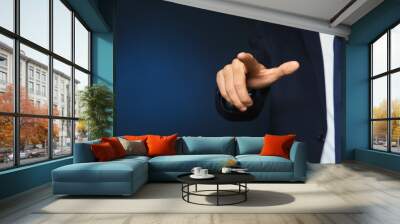 Businessman pointing on color background, closeup view of hand with space for text Wall mural