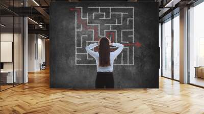 Businesswoman looking at chalkboard with illustration of maze Wall mural