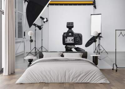 Camera on tripod, bar stool and professional lighting equipment in modern photo studio Wall mural