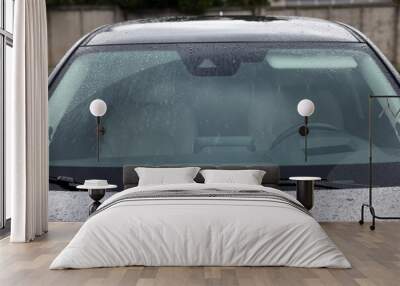 Car wipers cleaning water drops from windshield glass outdoors, closeup Wall mural