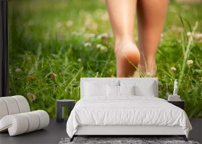 Child walking barefoot on green grass outdoors, closeup. Space for text Wall mural