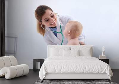 Children's doctor examining baby with stethoscope in hospital. Space for text Wall mural