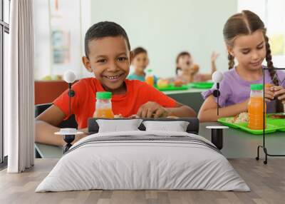 Children sitting at table and eating healthy food during break at school Wall mural