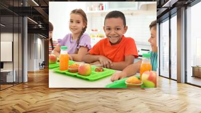 Children sitting at table and eating healthy food during break at school Wall mural