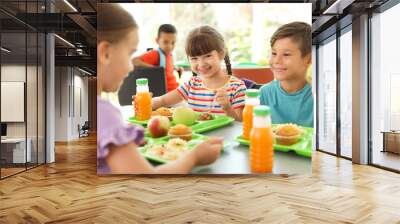 Children sitting at table and eating healthy food during break at school Wall mural