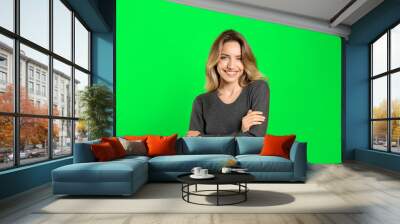 Chroma key compositing. Pretty young woman smiling against green screen Wall mural