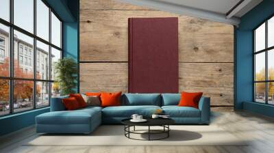 Closed hardcover book on wooden table, top view Wall mural